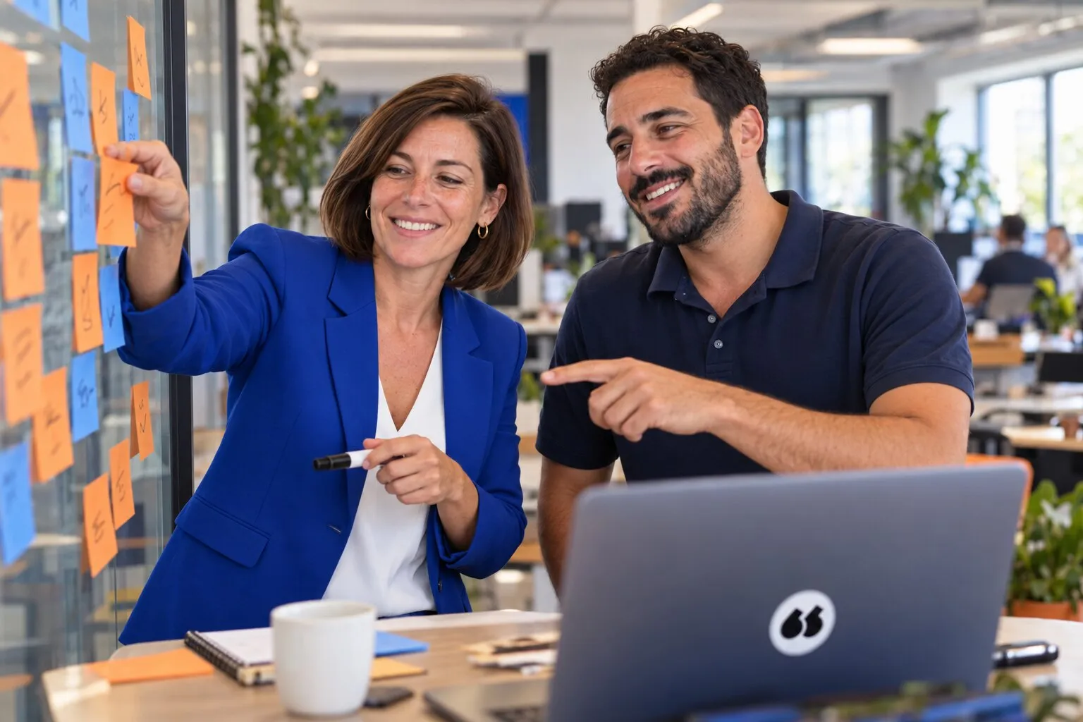 Une responsable commerciale et un account executive trient leurs critères de choix sur un mur de post-it