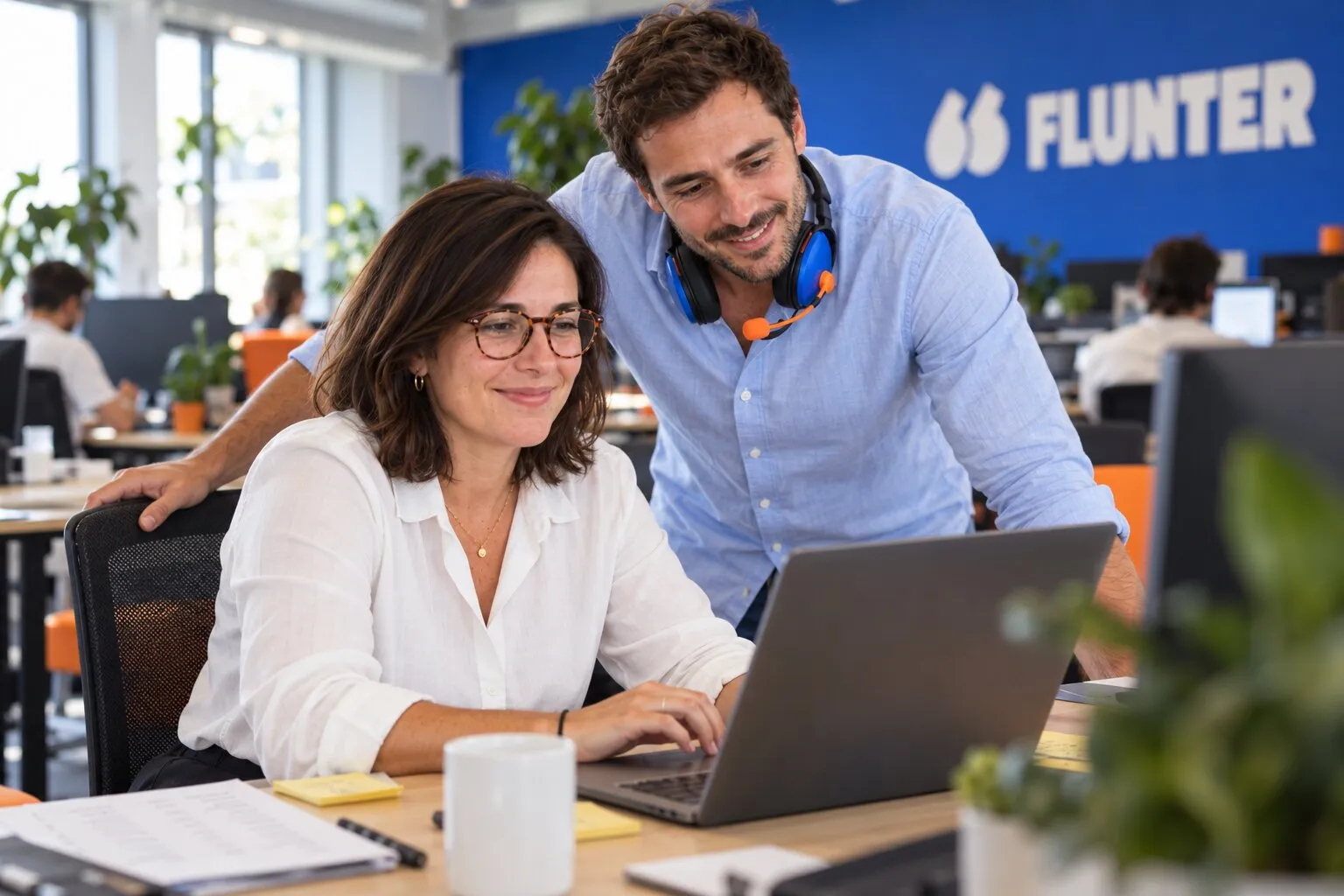 Une responsable sales ops lance une campagne d'appels depuis le CRM, un commercial au casque regarde son écran