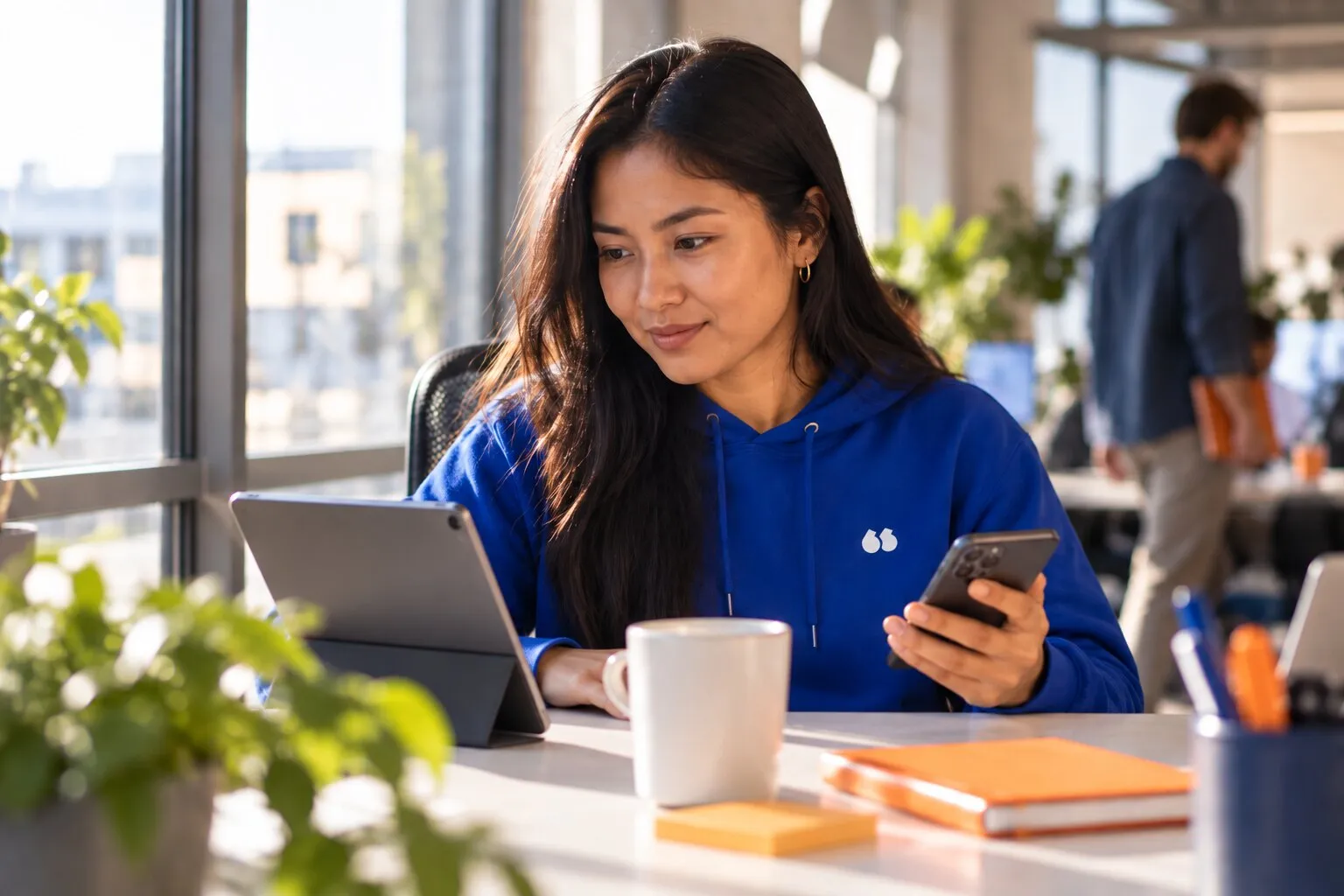 Une commerciale consulte la fiche d'un prospect sur sa tablette avant de le rappeler